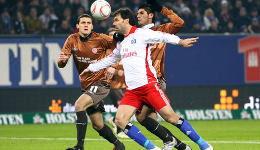 HSV-Stürmer Ruud van Nistelrooy wird von den Pauli-Spielern Ralph Gunesch (l.) und Carlos Zambrano (r.) im Duell um den Ball in die Mangel genommen
