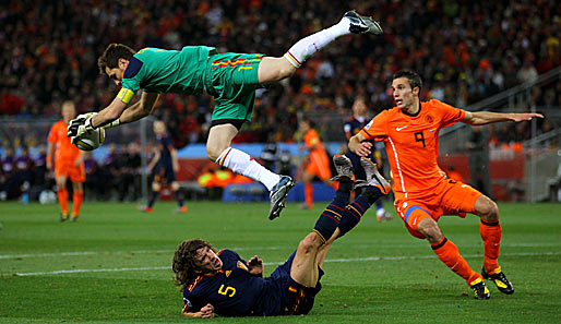 Kommt ein Iker geflogen...Casillas schnappt sich die Kugel vor dem am Boden liegenden Puyol, van Persie (r.) schaut zu