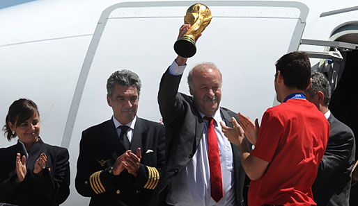 Spaniens Weltmeistertrainer Vicente del Bosque präsentiert stolz die Trophäe, die Flugzeugbesatzung applaudiert eher höflich als ekstatisch