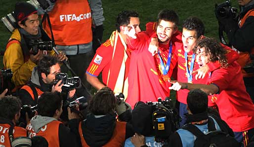 Gerard Pique, Cesc Fabregas und Carles Puyol posieren derweil für die Fotografen. Einem Weltmeister gebührend im Scheinwerferlicht