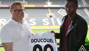 17. Juni 2016: Gladbach-Sportdirektor Max Eberl ist die Freude ins Gesicht geschrieben, als er gemeinsam mit Doucoure bei dessen Vorstellung posiert. Ablösefrei sicherten sich die Fohlen die Dienste des PSG-Juwels. Doch schon damals gibt es Probleme.