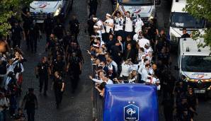 Bei der Einfahrt auf die Champs-Elysees stemmt Raphael Varane stolz den WM-Pokal in die Höhe.