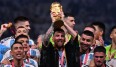Lionel Messi reckt den WM-Pokal in die Höhe - mit einem Bisht über dem Nationaltrikot.