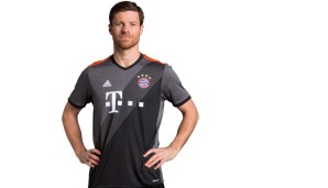 BAYERN MÜNCHEN: Wirkt Xabi Alonso nun glücklich oder nicht? Der Spanier durfte das neue Auswärtstrikot der Bayern anprobieren - grau, grau, grau mit orange.