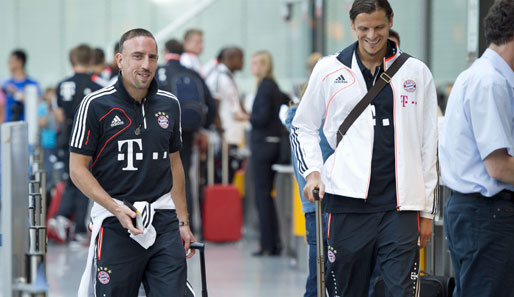 Auch ohne viel Schlaf können Franck Ribery (l.) und Daniel van Buyten (r.) am Flughafen lachen