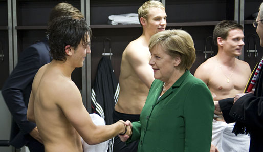 Bundeskanzlerin Angela Merkel gratuliert Mesut Özil (l.) nach dem EM-Quali-Sieg gegen die Türkei